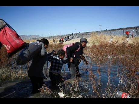 Migrants wade through the Rio Grande to reach the United States from Ciudad Juarez, Mexico, December 27.