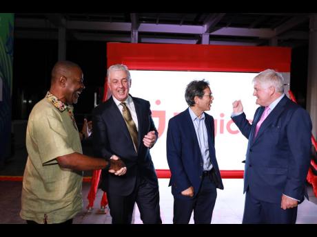 ABOVE: Harry Smith, Digicel Jamaica board chairman, congratulating Oliver Coughlan, retiring Digicel Group chief executive officer, while Anthony Chang, board director, Digicel Jamaica, engages Denis O’Brien, founder and chairman of Digicel.