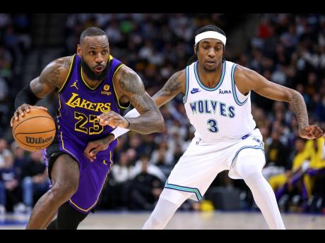Los Angeles Lakers forward LeBron James (left) works toward the basket as Minnesota Timberwolves forward Jaden McDaniels (3) defends during the second half of an NBA basketball game Saturday, December 30, 2023, in Minneapolis. 