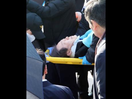 South Korean opposition leader Lee Jae-myung, on a stretcher, is carried by a rescue team in Busan, South Korea, on Tuesday, January 2. Lee was attacked and injured by an unidentified man during a visit to the southeastern city of Busan, emergency official