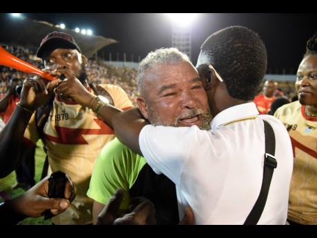 
Mona High School supporters congratulate coach Craig Butler for leading the institution to its first Manning Cup title inside the National Stadium on December 8, 2023.