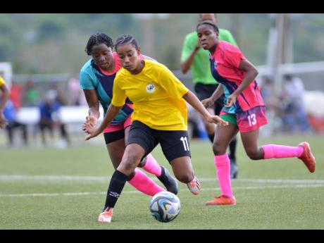 
Cavalier’s Liha Williams (centre) gets away from Frazsiers Whip’s Nevillegail Able during the final of the Jamaica Women’s Knockout football competition at the UWI-JFF Captain Horace Burrell Centre of Excellence on May 13, 2023.