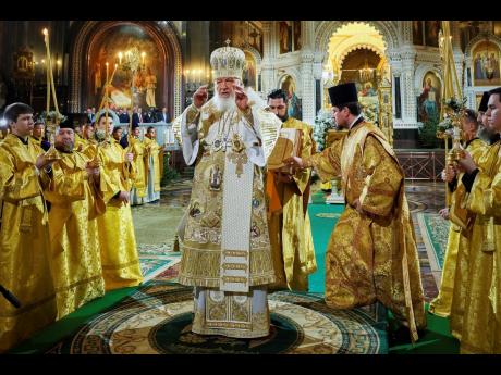 In this photo released by Russian Orthodox Church Press Service, Russian Orthodox Patriarch Kirill, centre, delivers the Christmas service in the Christ the Saviour Cathedral in Moscow.