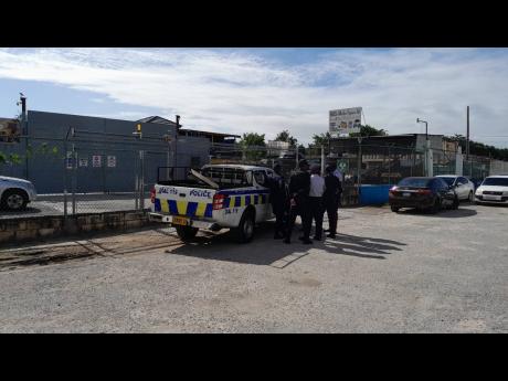 Credit: Photo by Corey Robinson
A police team outside a location in Portmore, St Catherine, last week after they disrupted activities at what is suspected to be an illegal LPG filling station.