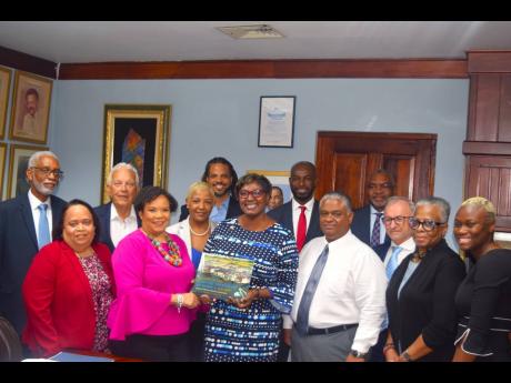 President of the Shipping Association of Jamaica Corah Ann Robertson Sylvester (front row, second from left) presents a copy of the organisation’s ‘History of the Shipping Association of Jamaica, 1939-2005: Jamaica’s premier maritime institution’ t
