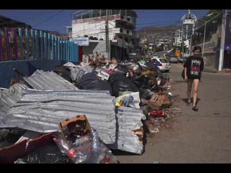 A resident walks past debris more than two weeks after Hurricane Otis hit Acapulco, Mexico, as a Category 5 storm on November 13, 2023. 