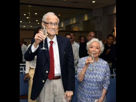 Credit: Ashley Anguin Patriarch Karl Hendrickson (left) and his wife Nel lift their glasses in celebration of Karl’s 94th birthday during the National Baking Company Limited’s unveiling event for the plant being built in Catherine Hall, St James.