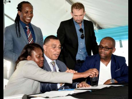 Ian Allen
Prime Minister Andrew Holness (centre) looks on as Arlene Williams (second left), Permanent Secretary in the Ministry of Economic Growth and Job Creation, puts the official stamp on the contract for the building of ‘Resilience Park’ in Portmo