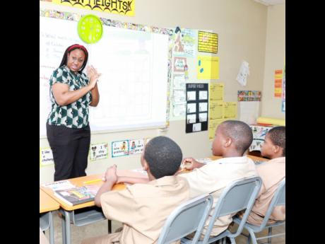 Sashaoir Hewitt (centre), grade five teacher at the Danny Williams School for the Deaf, signs during a class session with her grade five students. 