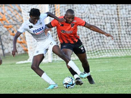 Credit: Rudolph Brown Jerome McLeary (left) of Cavalier and Richard Brown of Tivoli Gardens in a tussle for the ball during yesterday’s Jamaica Premier League match at the Anthony Spaulding Sports Complex. The game ended in a 0-0 draw.