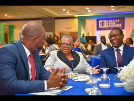 Minister of Finance and the Public Service Dr Nigel Clarke (right) and managing director, Jamaica Stock Exchange Group, Dr Marlene Street Forrest, is engaged with deputy chairman, Jamaica Stock Exchange, Steven Whittingham, during Wednesday’s session of 