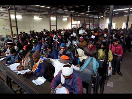 Indian workers aspiring to be hired for jobs in Israel fill their forms during a recruitment drive in Lucknow, India, yesterday.