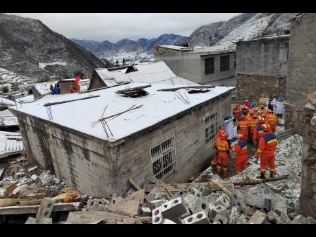Rescue workers search the site of a landslide in Liangshui village, Tangfang Town in the city of Zhaotong, southwestern China’s Yunnan Province, on Monday.