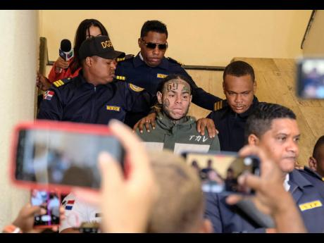Rapper Daniel Hernandez, known as Tekashi 6ix9ine, is escorted by police as he arrives for a court hearing at the Palace of Justice, in Santo Domingo, Dominican Republic.
