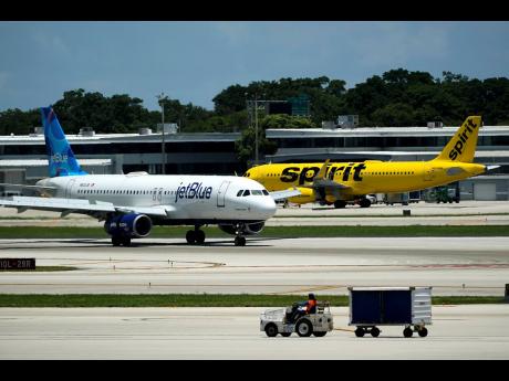 
A JetBlue Airways Airbus A320 (left) passes a Spirit Airlines Airbus A320 as it taxis on the runway at the Fort Lauderdale-Hollywood International Airport in Fort Lauderdale, Florida. JetBlue and Spirit Airlines are appealing a judge’s ruling that is bl
