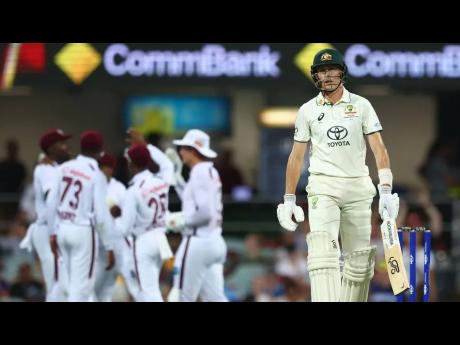 Australia’s Marnus Labuschagne (right) walks away a dejected figure as West Indies players celebrate on the third day of their Test match at the Gabba in Australia on Saturday.