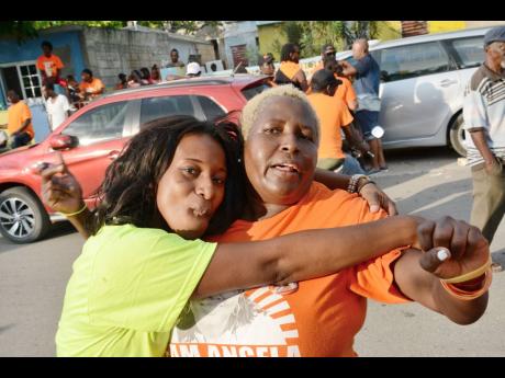 In this November 2016 photo, supporters of JLP (left) and PNP are seen celebrating during the local government election. 