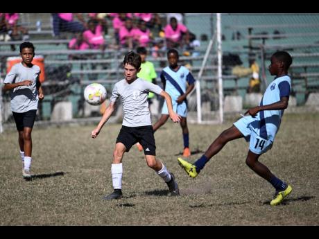 Credit: Ricardo Makyn
Hillel Academy (grey) and Balmagie Primary go up against each other in group stage action at the Youth Football League Junior Cup all-island competition at the University of the West Indies’ Mona Bowl yesterday.