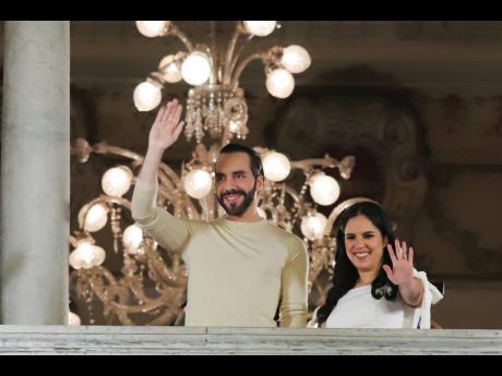 El Salvador’s President Nayib Bukele and his wife Gabriela Rodriguez wave to supporters from the balcony of the presidential palace in San Salvador, El Salvador, after polls closed for general elections on Sunday.