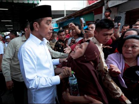 Indonesian President Joko Widodo, left, listens to an elderly woman during his visit to Tanah Tinggi neighbourhood in Jakarta in 2019