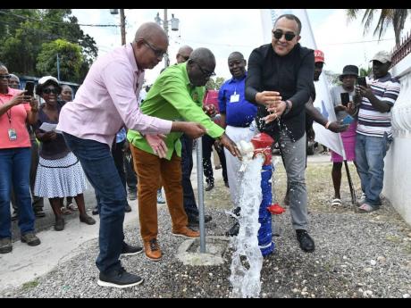 Credit: Contributed Local Government Minister Desmond McKenzie (centre) flanked by Norman Scott (right), chairman of the St Catherine Municipal Corporation, and Dr Christopher Tufton, member of parliament for St Catherine West Central, when they turned on the water in Water