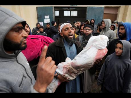 Palestinians chant Islamic slogans while carry the bodies of children killed in the Israeli strikes in the Gaza Strip in front of the morgue at Al Aqsa hospital in Deir al Balah, Gaza Strip.