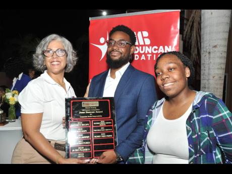 Kim Mair (left), CEO of JMMB Joan Duncan Foundation, presents the Joan Duncan Award for Corporate Social Responsibility, and $50,000 to budding entrepreneurs Robert Williams (centre) and Rhea Johnson of Green Worx, during the recent Vincent HoSang/UWI Vent