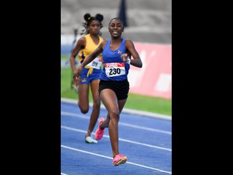 Hydel High School’s Nastassia Fletcher grimaces as she runs away with the under-17 girls’ 400 metres at the Carifta Trials inside the National Stadium yesterday. 