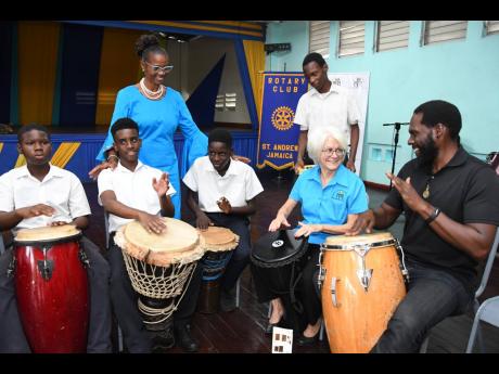 Dr Elizabeth Ward (second right), chair of the Violence Prevention Alliance (VPA), gets drumming lessons from Jesse Golding (right), Afro-Caribbean drumming instructor, at the launch of the VPA’s drumming programme at the Kingston Young Women’s Christi