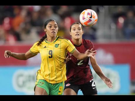 Canada’s Sydney Collins (2) battles with Jamaica’s Kameron Simmonds (9) for the ball during the first half of a CONCACAF Women’s Championship game in Toronto on September 26, 2023.  