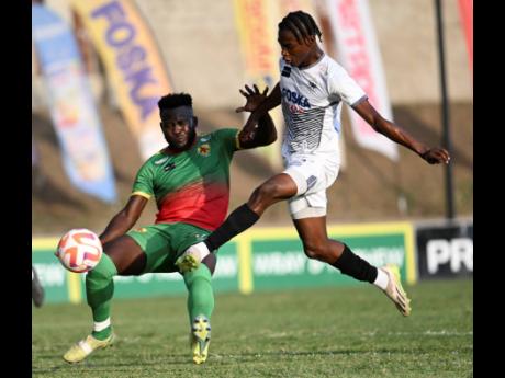 Humble Lion’s defender Ricardo Campbell (left) tackles  Cavalier forward  Jalmaro Calvin during their Jamaica Premier League encounter at the Stadium East field on Monday, March 4, 2024.