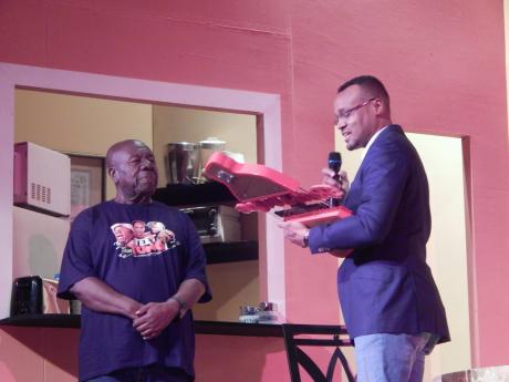 Credit: Michael Reckord Oliver Samuels (left) receiving his Red Stripe Living Legend award from Brand Manager Nathan Nelms at the Little Theatre on Friday night.