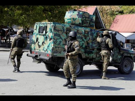 Members of the General Security Unit of the National Palace, set up a security perimeter around one of the three downtown stations after police fought off an attack by gangs the day before, in Port-au-Prince, Haiti, Saturday, March 9.