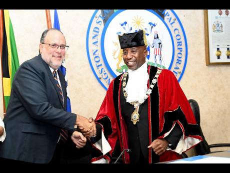 Opposition Leader Mark Golding (left) congratulates newly selected Mayor of Kingston Andrew Swaby during yesterday’s meeting of the Kingston and St Andrew Corporation at its office in downtown Kingston. 