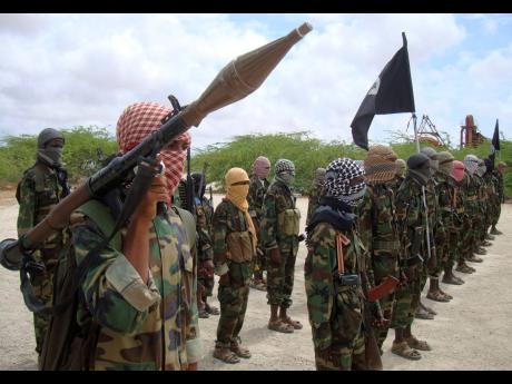 In this 2010 photo Al-Shabaab fighters display weapons as they conduct military exercises in northern Mogadishu, Somalia.