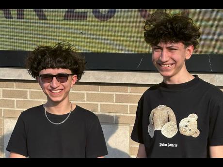 Adam Mortada (left) and his older brother Hussein Mortada stand outside Dearborn High School.