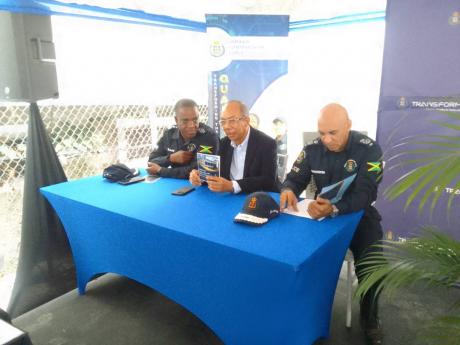 Incoming Commissioner of Police Dr Kevin Blake (left) speaks with Dr Horace Chang (centre), minister of national security, as Major General Antony Anderson, outgoing commissioner of police, sits by during the opening of the Hopewell Police Station, in Hano