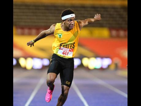 Excelsior High’s Damor Miller dips to win the Class One boys' 100 metres title at the ISSA/GraceKennedy Boys and Girls' Athletics Championships at the National Stadium tonight.