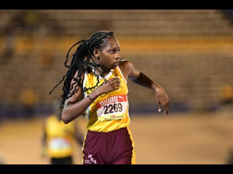 Muschett High School's Shanoya Douglas looks at the clock as she crosses the finish line to win the the girls' Class 2 400 metres at the ISSA/GraceKennedy Boys and Girls' Athletics Championships inside the National Stadium this evening.