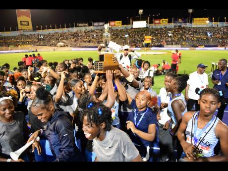 Edwin Allen High’s girls celebrate with the championship trophy at the end of the 2024 ISSA/Grace Kennedy Boys and Girls Championships at the National Stadium on Saturday night.