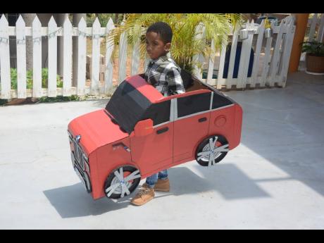 Little Javontae Gayle tries out his model car made by Cardboard Master, Gawayne James.