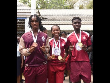 Credit: Ashley Anguin Muschett High School’s medallists – Shanoya Douglas (centre) double gold medallist, Class Two girls’ 200 metres and 400 metres, Osmond Holt (left) bronze medallist in the decathlon and Johan-Ramaldo Smythe, gold medallist in the Class Two 200 metres