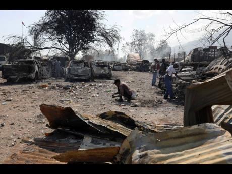 Credit: AP People look for salvageable items at a car mechanic shop that was set on fire during gang violence in Port-au-Prince, Haiti, on Monday, March 25, 2024.