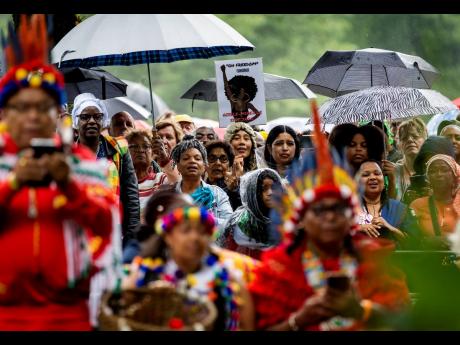 Spectators listen to Dutch King Willem-Alexander who apologized for the royal house’s role in slavery and asked forgiveness in a speech greeted by cheers and whoops at an event to commemorate the anniversary of the country abolishing slavery in Amsterdam