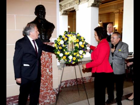 Jamaica’s Ambassador to the United States and permanent representative to the Organization of American States (OAS), Audrey Marks, places a floral tribute at the bust of Jamaica’s First National Hero, the Right Excellent Marcus Mosiah Garvey, in the Ha