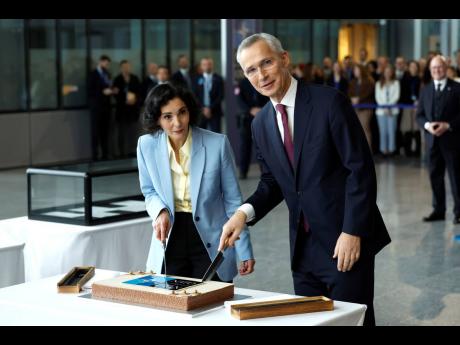 NATO Secretary General Jens Stoltenberg (right), and Belgium’s Foreign Minister Hadja Lahbib cut a cake during a ceremony to mark the 75th anniversary of NATO at NATO headquarters in Brussels on Thursday. 