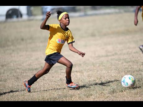 Norbrook Strikers’ Orania Campbell goes on a dribble during one of the Youth Football League’s Junior Cup all-island games at the University of the West Indies’ Mona Bowl in February.