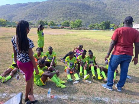 Edith Dalton James High School coach Omar Taffe (right) talks to his team at the halftime break of their Tip/Friendly schoolgirl football Zone C quarterfinal match against Decarteret College at Edith Dalton James, on Friday 