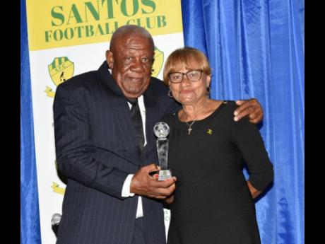 President of Santos Football Club, Carlton ‘Spanna’ Dennis (left),  presents the President’s Award to Lorna Bell, the widow of former Santos coach Winthorpe ‘Jackie’ Bell, during the club’s 60th year anniversary awards ceremony and dinner last 