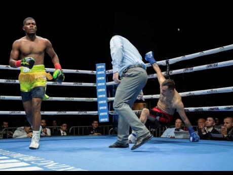 Credit: Contributed Jerone Ennis (left) walks back to his corner after knocking down Argentinian Marcelo Adrian Fernande in a light-heavyweight boxing contest at the Pickering Casino Resort on Saturday night.